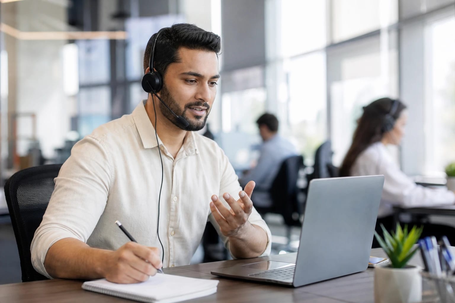 Sales representative on a phone call at a desk with a headset