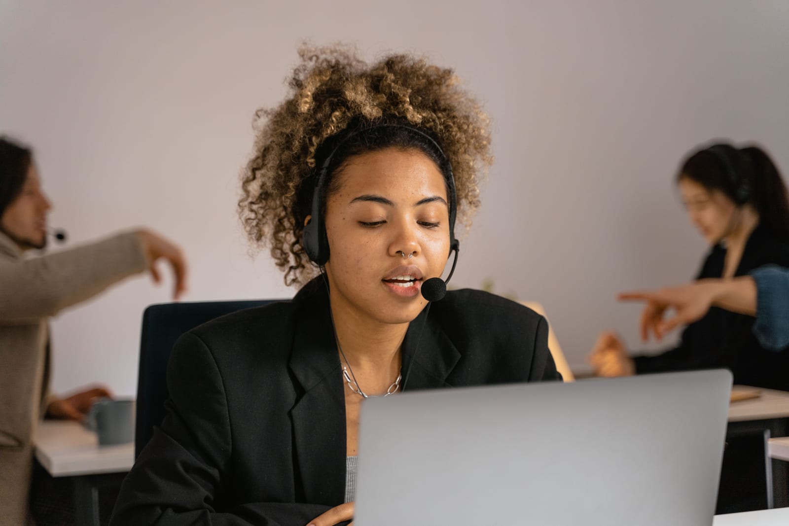 A customer support agent wearing a headset working at a laptop